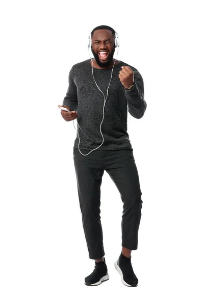 African-American man listening to music on white background — Stock Photo, Image