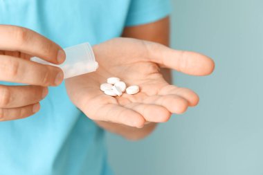 Renkli arka planda hapları olan adam, yakın plan