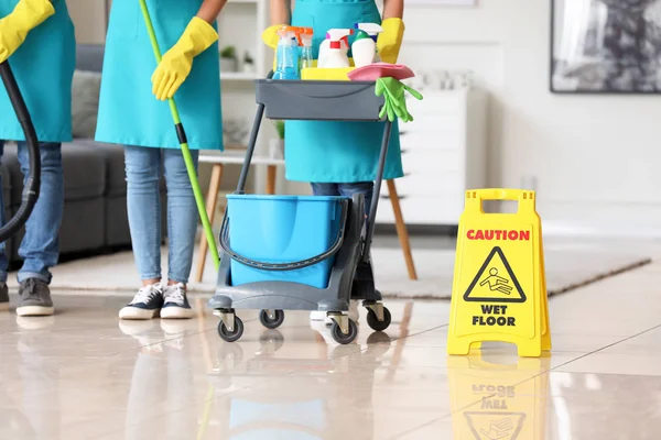 Team of janitors with cleaning supplies in room — Stock Photo, Image