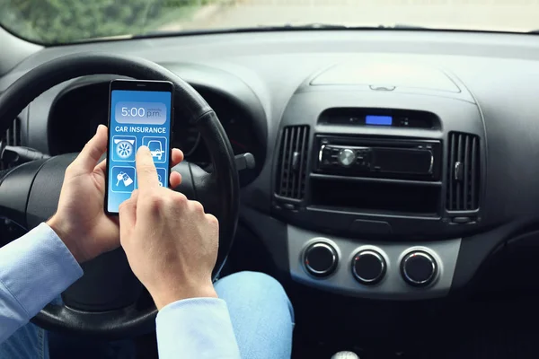 Motorista com telefone celular usando o aplicativo de seguro de carro em auto — Fotografia de Stock