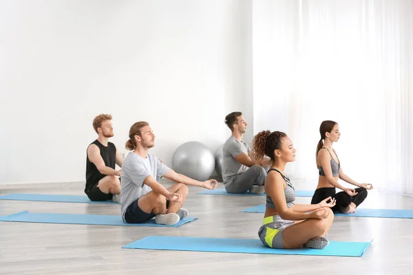 Grupo de pessoas praticando ioga no ginásio — Fotografia de Stock