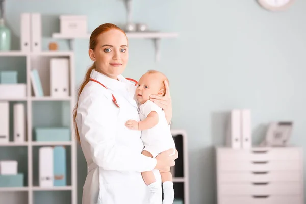 Pediatra con lindo bebé en la clínica — Foto de Stock