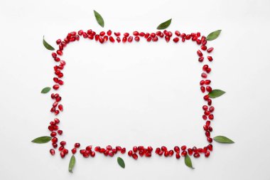 Beyaz zemin üzerinde lezzetli nar tohumlarından yapılmış çerçeve