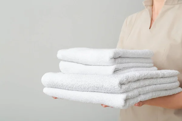 Woman with clean soft towels on light background — Stock Photo, Image