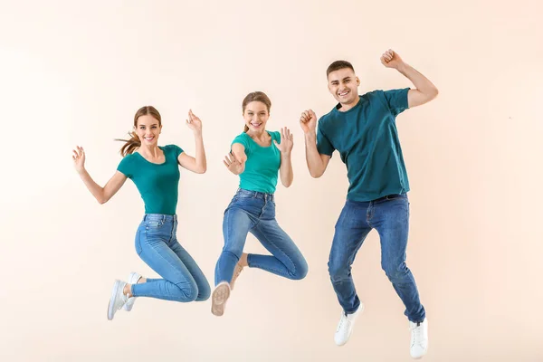 Jumping young people against color background — Stock Photo, Image