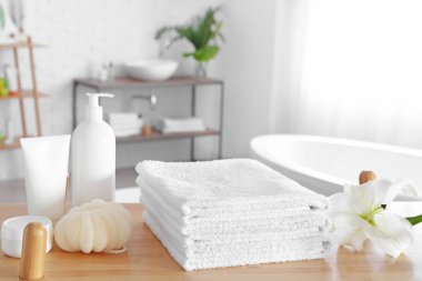 Tuvaletteki masada yumuşak havlular ve kozmetik ürünler.