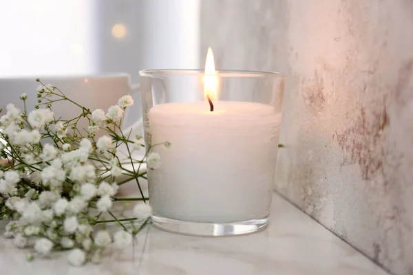 Burning candle, notebook and flowers on table — Stock Photo, Image