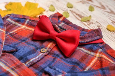 Beyaz ahşap arka planda şık sonbahar çocuğu kıyafetleri, yakın plan.