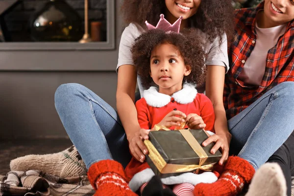 Happy African-American family with gift at home on Christmas eve — Stock Photo, Image