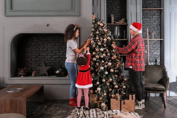 Glückliche afrikanisch-amerikanische Familie schmückt Weihnachtsbaum zu Hause — Stockfoto