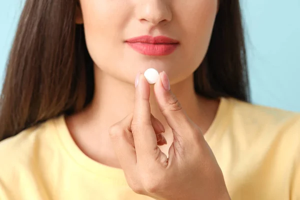 Νεαρή γυναίκα που παίρνει φάρμακα για το χρώμα του φόντου, closeup — Φωτογραφία Αρχείου