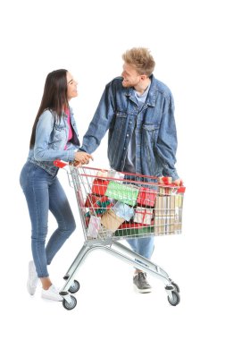 Beyaz arka planda Noel hediyeleriyle dolu alışveriş arabası olan genç bir çift.