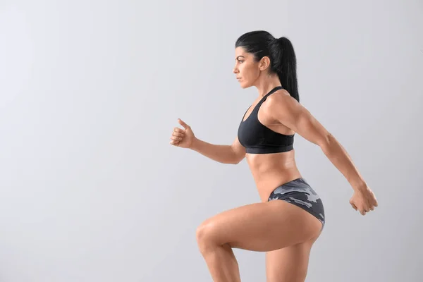 Sportig muskulös kvinna på ljus bakgrund — Stockfoto