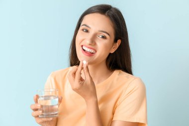 Genç bir kadın renk geçmişiyle ilaç alıyor.