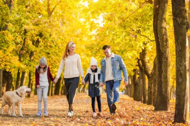 mutlu bir aile sonbahar parkta yürüyüş