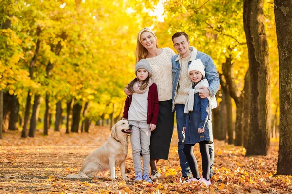 Happy family with dog in autumn park — Stock Photo, Image