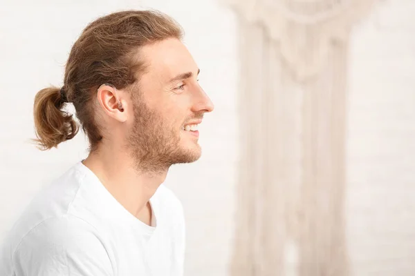 Joven con audífono en casa — Foto de Stock