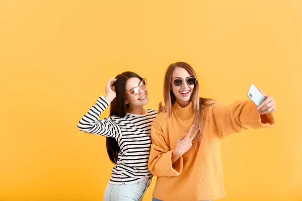 Mujeres felices tomando selfie sobre fondo de color — Foto de Stock