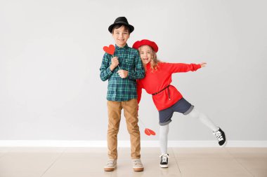 Gri arka planda kırmızı kalpli şirin çocuklar. Sevgililer Günü kutlaması