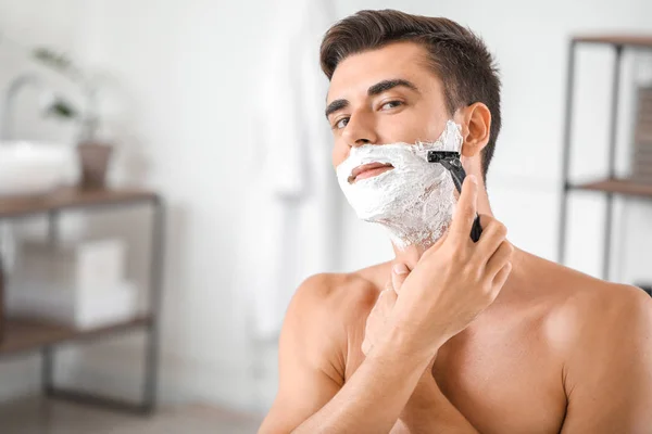 英俊的年轻人在家里刮胡子 — 图库照片