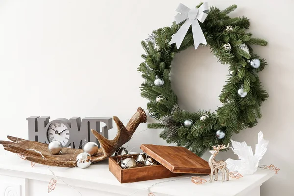 Bela grinalda de Natal pendurada na parede perto da lareira com decoração — Fotografia de Stock