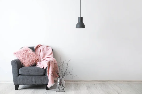 Stylish armchair with plaid near light wall — Stock Photo, Image