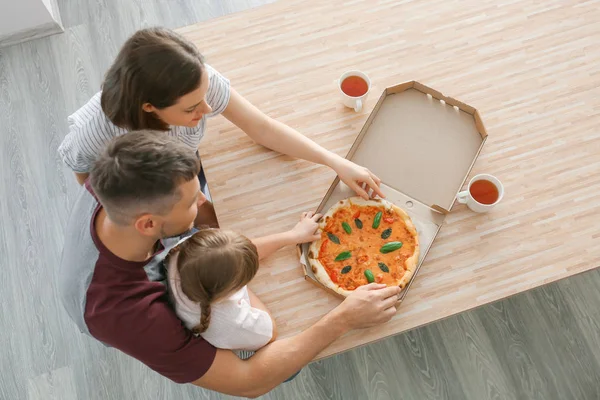 Šťastná rodina jíst pizzu doma — Stock fotografie