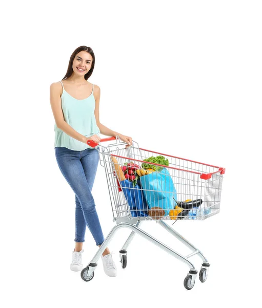 Jovem mulher com carrinho de compras no fundo branco — Fotografia de Stock