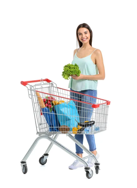 Jovem mulher com carrinho de compras no fundo branco — Fotografia de Stock