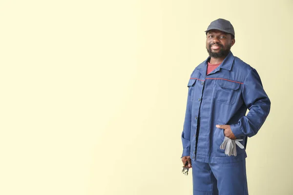 African-American car mechanic on color background — Stock Photo, Image