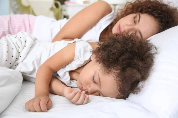 Malá afroameričanka s matkou spící v posteli — Stock fotografie