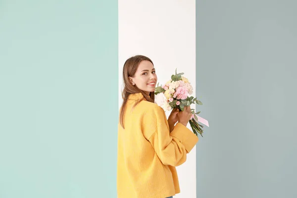 Beautiful young woman with bouquet of carnation flowers on color background — Stock Photo, Image