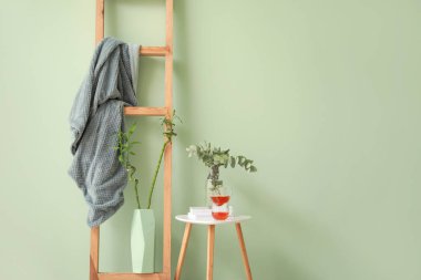 Çay fincanları ve renkli arkaplanda ekoseli merdiven olan masa.