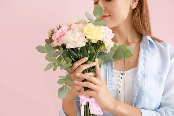 Beautiful young woman with bouquet of carnation flowers on color background — Stock Photo, Image