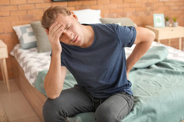 Young man suffering from back pain at home — Stock Photo, Image