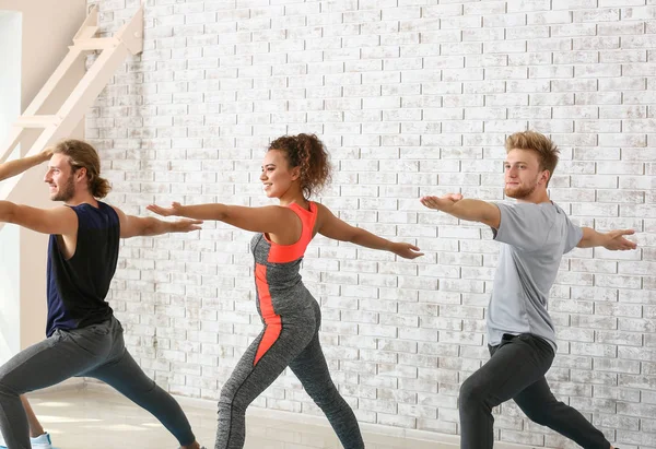 Gruppe von Menschen, die Yoga in der Turnhalle praktizieren — Stockfoto