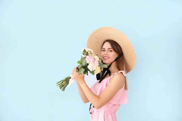 Beautiful young woman with bouquet of carnation flowers on color background — Stock Photo, Image