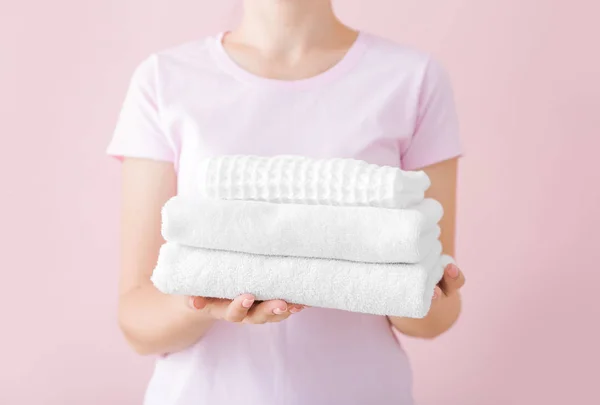 Woman holding clean towels on color background — Stock Photo, Image