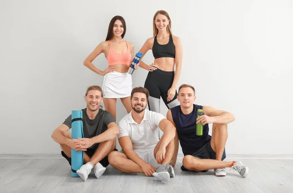 Groep van sportieve vrienden bij witte muur — Stockfoto