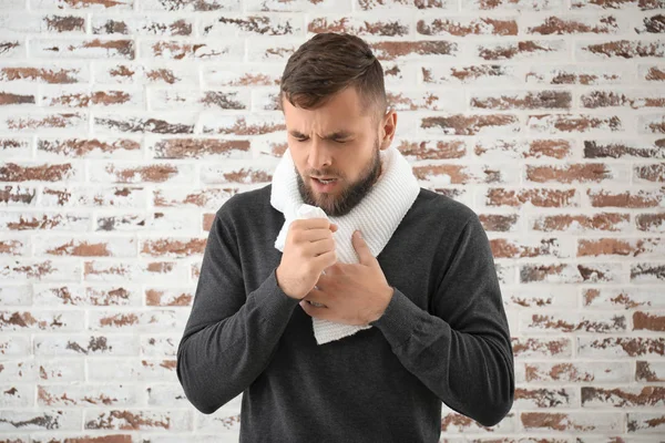 Portrait of sick man against brick wall — Stock Photo, Image