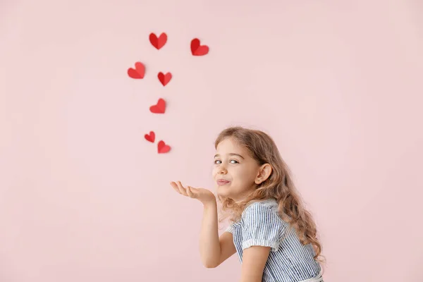 Söt liten flicka skicka romantisk luft kyss på färg bakgrund. Alla hjärtans dag firande — Stockfoto