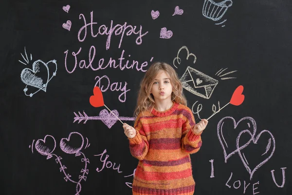 Söt liten flicka med pappershjärtan nära mörk vägg. Alla hjärtans dag firande — Stockfoto