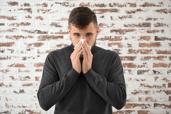 Portrait of sick man against brick wall — Stock Photo, Image