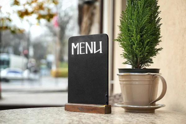 Empty menu board on table in outdoor cafe — Stock Photo, Image