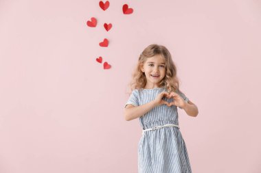 Renkli arka planda kalp şeklinde el ele tutuşan tatlı küçük kız. Sevgililer Günü kutlaması