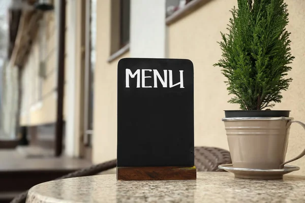 Пустая доска для меню на столе в кафе на открытом воздухе — стоковое фото