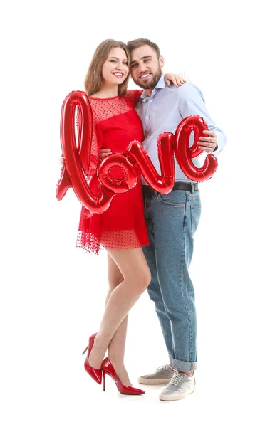 Happy young couple with balloon in shape of word LOVE on white background. Valentine's Day celebration — Stock Photo, Image