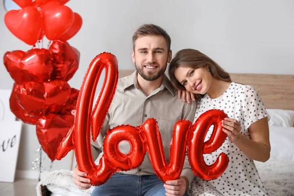 Счастливая молодая пара празднует День Святого Валентина дома — стоковое фото
