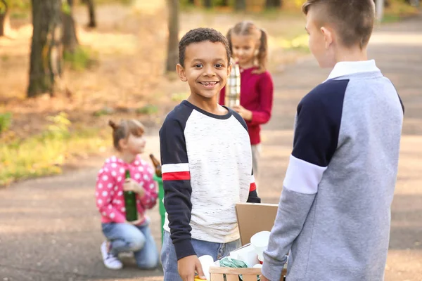 Les petits enfants ramassent les ordures à l'extérieur. Concept de recyclage — Photo