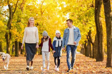 mutlu bir aile sonbahar parkta yürüyüş